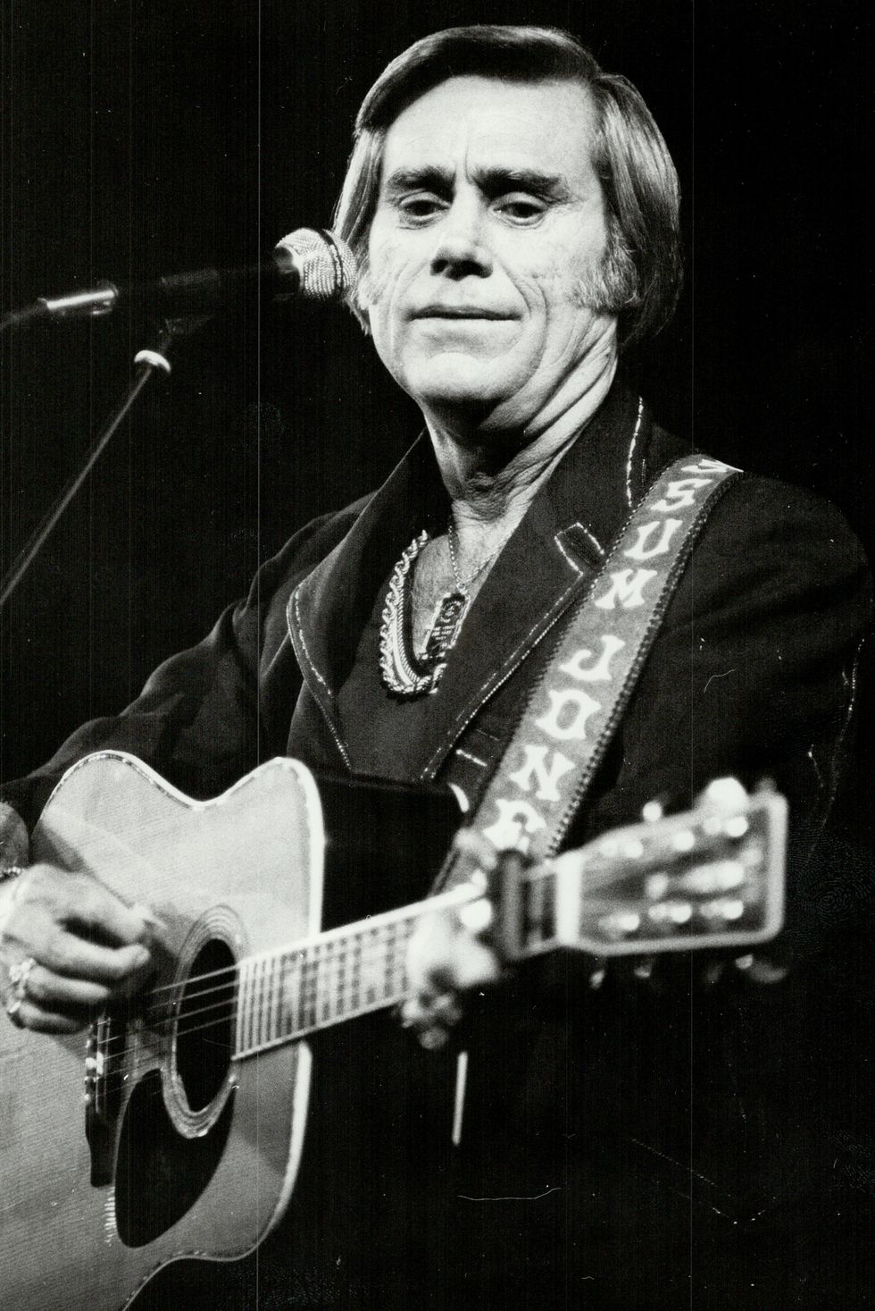 close up of singer george jones playing guitar at a concert