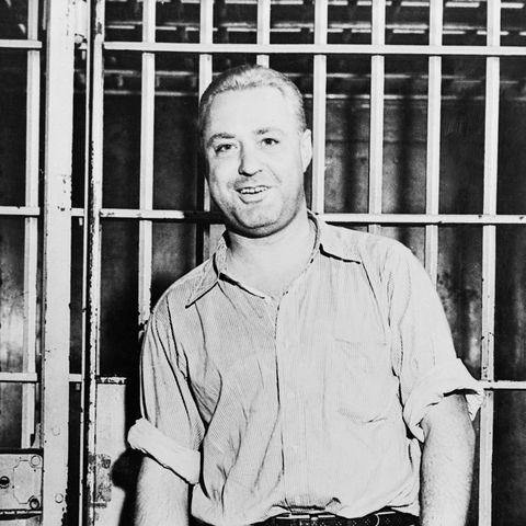 man handcuffed and standing near a prison cell