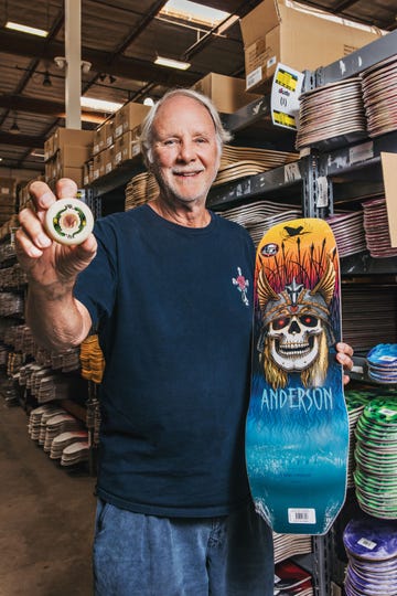 george powell holds a powell peralta dragon formula wheel and a bones brigade skateboard deck at the company’s factory in ventura, california
