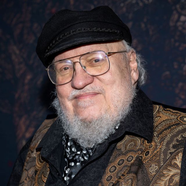 george r r martin wearing a hat and suit and looking toward a camera for a photo