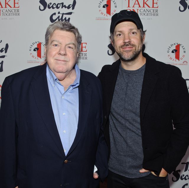 two men standing next to each other and smiling for a photograph