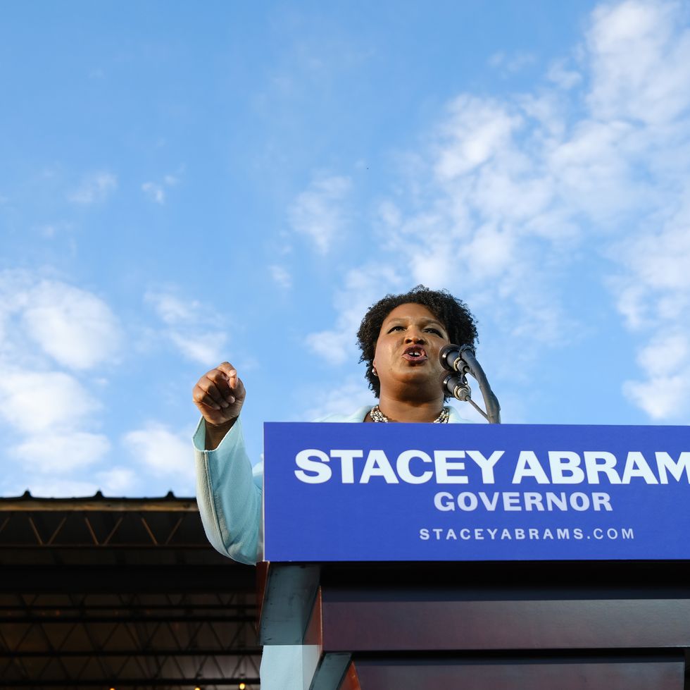 stacey abrams standing behind a lectern that says stacey abrams governor