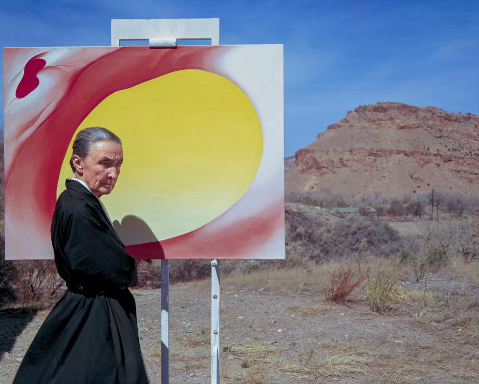 Georgia O'Keeffe poses outdoors beside an easel with a canvas from her series, 'Pelvis Series Red With Yellow,' in Albuquerque, New Mexico, 1960