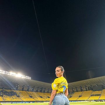 a person in a yellow shirt on a football field at night