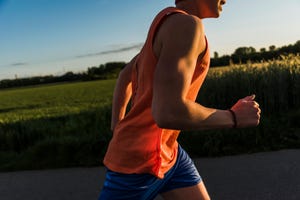 germany, young man jogging, arm, in the evening light