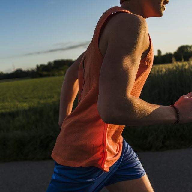 germany, young man jogging, arm, in the evening light