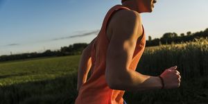 germany, young man jogging, arm, in the evening light