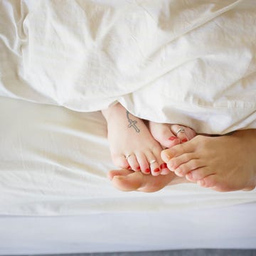 young couple in bed, feet touching