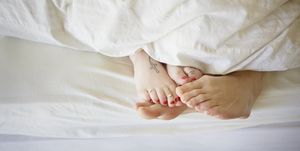 young couple in bed, feet touching