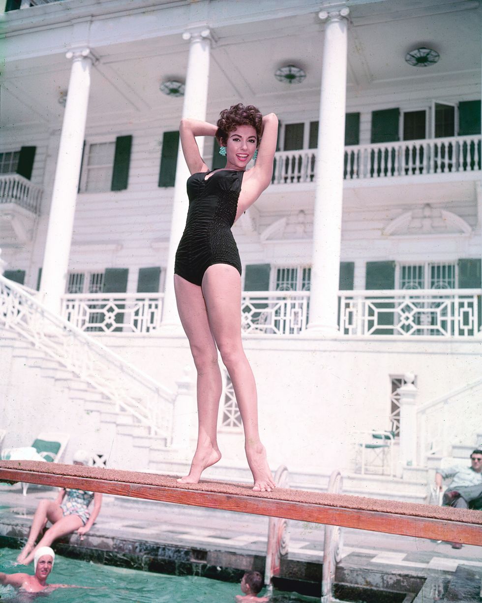 rita moreno, puerto rican singer, dancer and actress, wearing a black swimsuit, posing on a diving board on a swimming pool, with swimmers below, circa 1955 photo by silver screen collectiongetty images