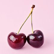 Close-Up Of Cherries Over Pink Background