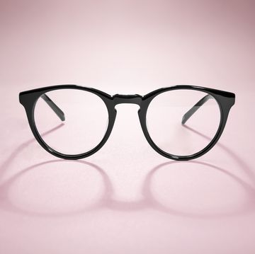 studio shot of black glasses with long shadow at pink background