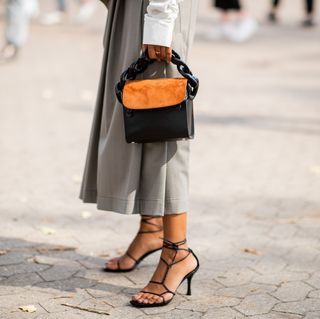 a woman at copenhagen fashion week wears strappy sandals to illustrate a guide to the best summer sandals 2023