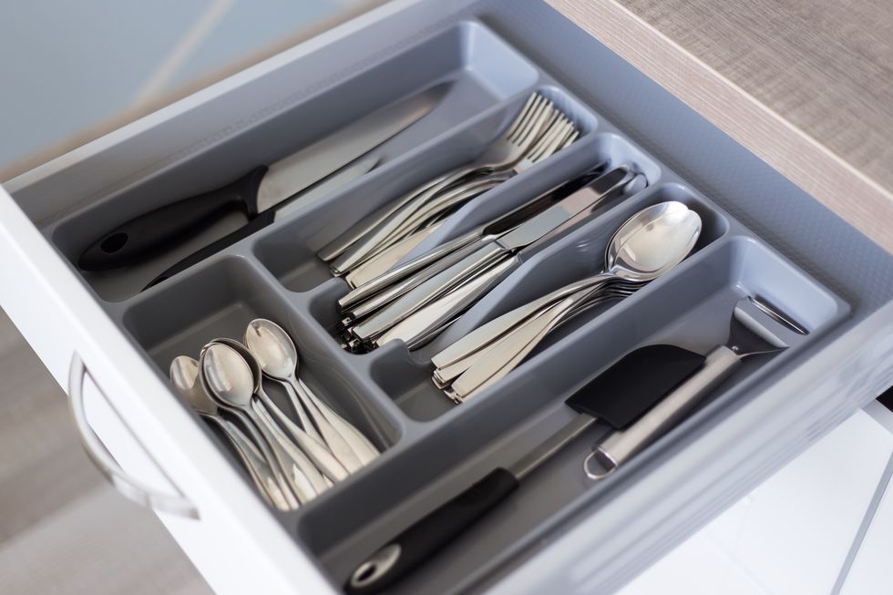 drawer with silver cutlery in modern kitchen