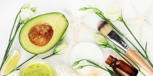 Avocado mask for beautiful skin and hair treatment. Facial mask in jar with essential oils and white blossom,