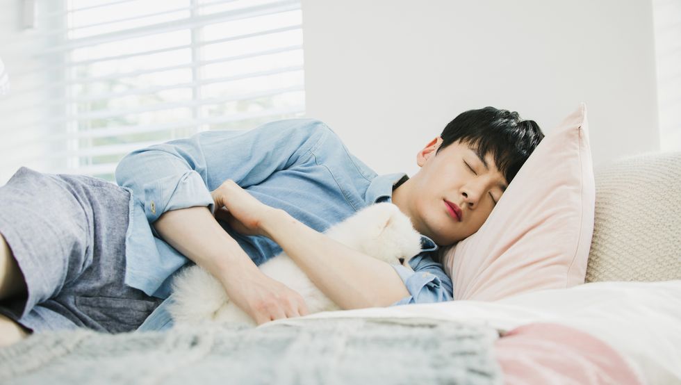 A man sleeping with a dog