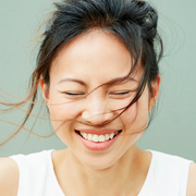 asian woman smiling with hair blowing in breeze