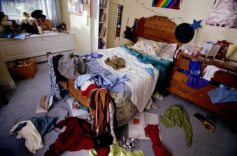 bedroom with clothes, books and cds thrown around