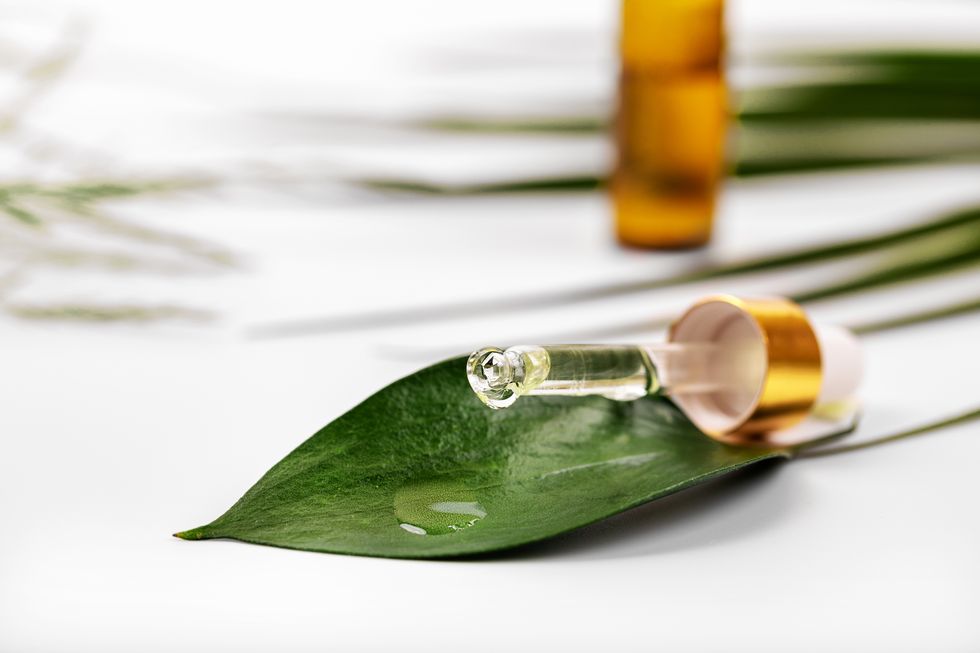 herbal medicine or cosmetics oil dropping on the green leaf from dropper