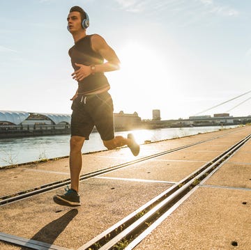Young athlete jogging in the city at the river persona corriendo al atardecer