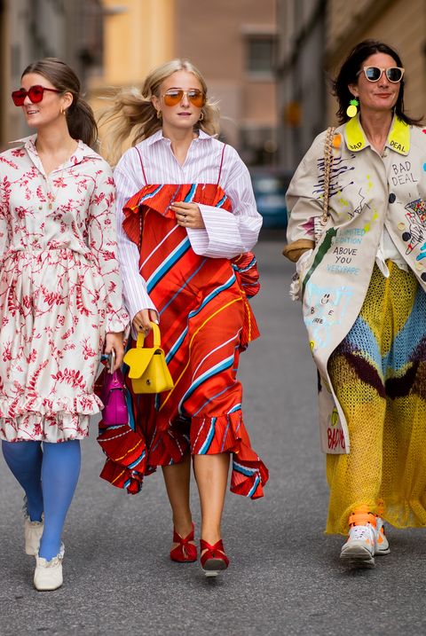 vier vrouwen lopen op straat in kleurrijke kleding