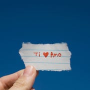 Hand holding I love you note written in Spanish words of affirmation