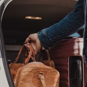 Man packing in his luggage suitcase in his car ready for road trip