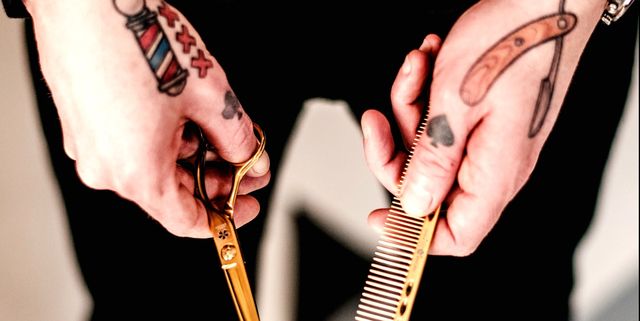 Midsection Of Barber With Tattooed Hands Holding Comb And Scissors At Shop