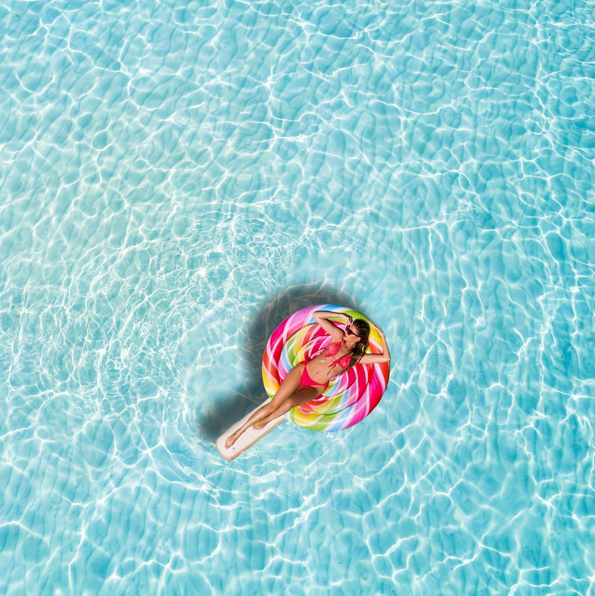 High Angle View Of Woman Lying On Inflatable Raft In Swimming Pool