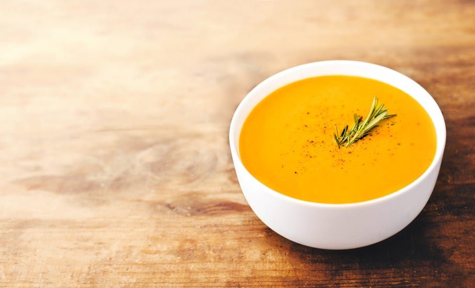 Squash Soup with Rosemary on rustic wooden table.  Autumn Pumpkin cream-soup with croutons. Top view. Copy space"n