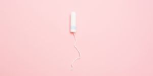 Clean white cotton tampons on pink background. Menstruation. Feminine Hygiene in periods, beauty treatment