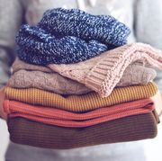 midsection of woman hand holding sweaters