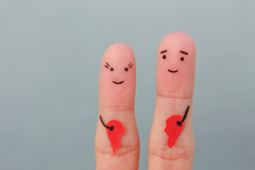Fingers art of happy couple. Woman and man holding broken heart. Concept of joy after divorce.