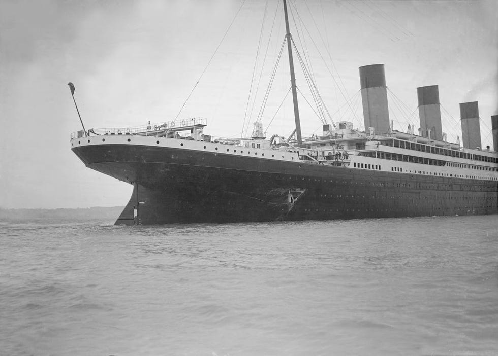 a large ship floats in water, a large gash appears in its hull
