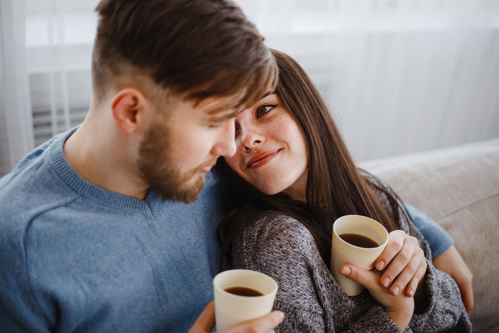 Couple drinking coffee in living room