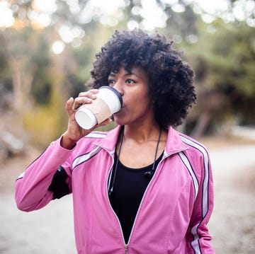 a young black woman walking with a cup of coffee