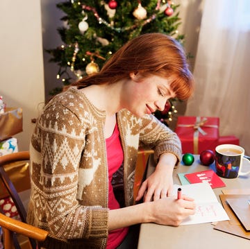 Woman writing christmas cards. what to write in a christmas card