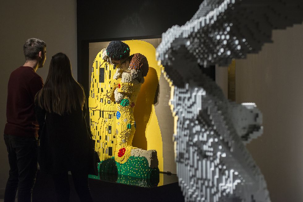 italy, turin, piedmont   20181114 two people look at the sculpture of the famous painting klimt's kiss done with lego bricks during the art of the brick, a contemporary art exhibition using lego bricks by the artist nathan sawaya the art exhibition the art of the brick showcases over 80 impressive and fascinating works by artist nathan sawaya, where he reconstructs iconographies, famous faces, scutures and paintings with the famous lego bricks creating lego sculptures photo by stefano guidilightrocket via getty images