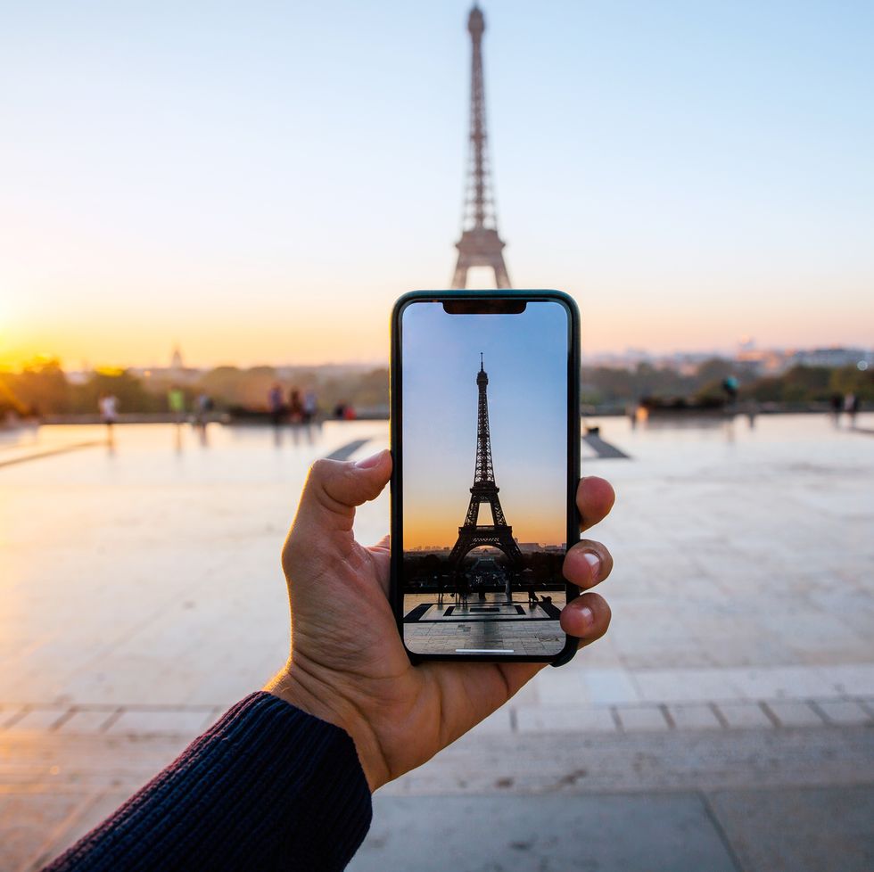 Tourist taking picture of Eiffel Tower with smart phone, personal perspective view, Paris, France