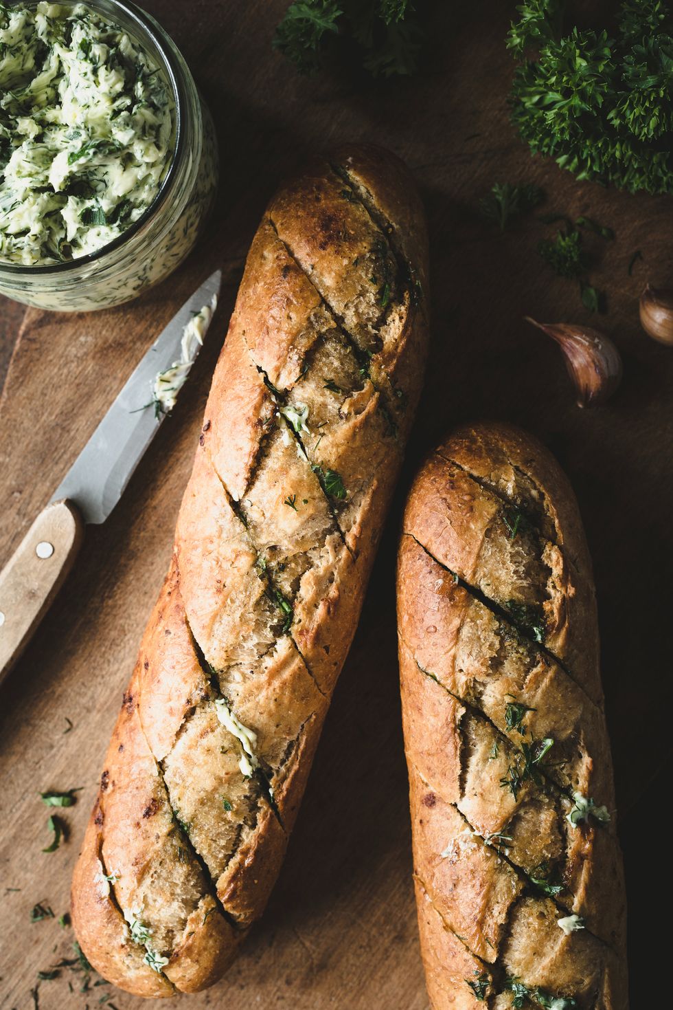 garlic butter baked baguette compound butter with herbs and garlic rustic food composition