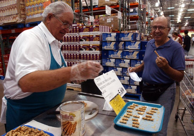 vaughn fish cq left, offers sample of  food  to buz smith saturday at costco this is a slice on the costco culturephoto by cliff grassmickdigital first mediaboulder daily camera via getty images
