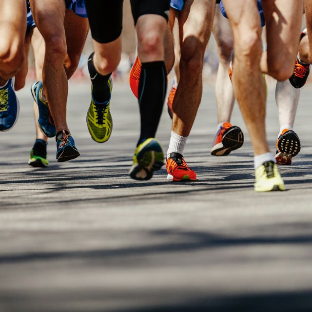 legs group men runners running on asphalt road