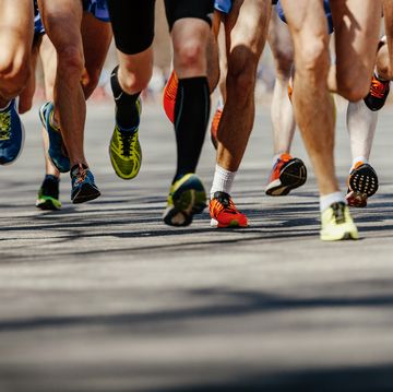 legs group men runners running on asphalt road