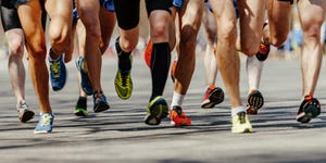 legs group men runners running on asphalt road