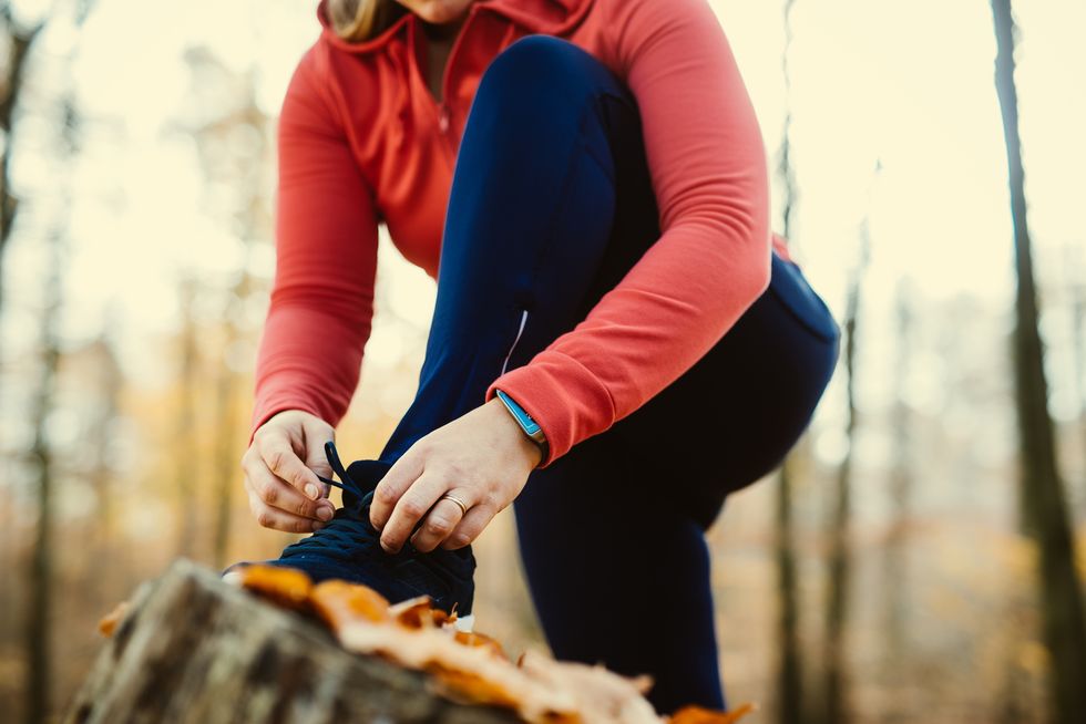 Woman fixing her shoelaces before jogging.