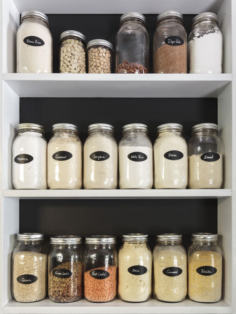 jars of flours and grains on white shelves in pantry