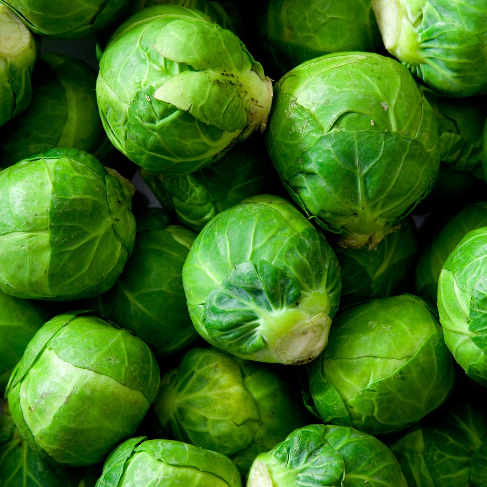 A dish full of uncooked, unpeeled sprouts a dish full of uncooked, unpeeled brussels sprouts natural, soft lighting