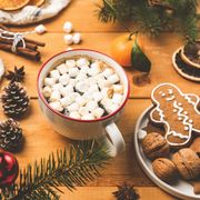 cup of hot chocolate with marshmallows and christmas decorations on wooden table closeup view cozy winter holidays composition