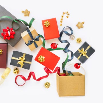 many gift boxes and ornaments flowing out from a box hold by hands depicting blessing, prosperity and generosity