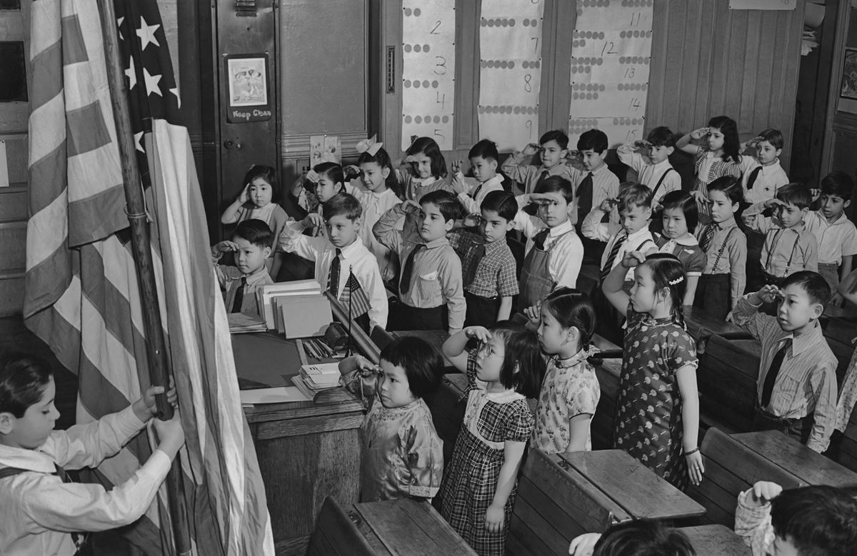 A group of children saluting the American flag at a school in the Chinatown area of Manhattan circa 1960